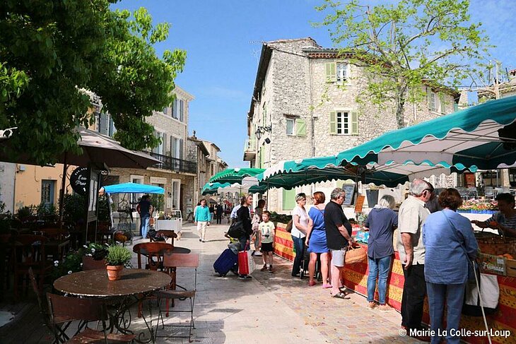 Scène de marché provençal à La Colle-sur-Loup, au cœur du village, parfaite pour illustrer l’art de vivre local et la convivialité.