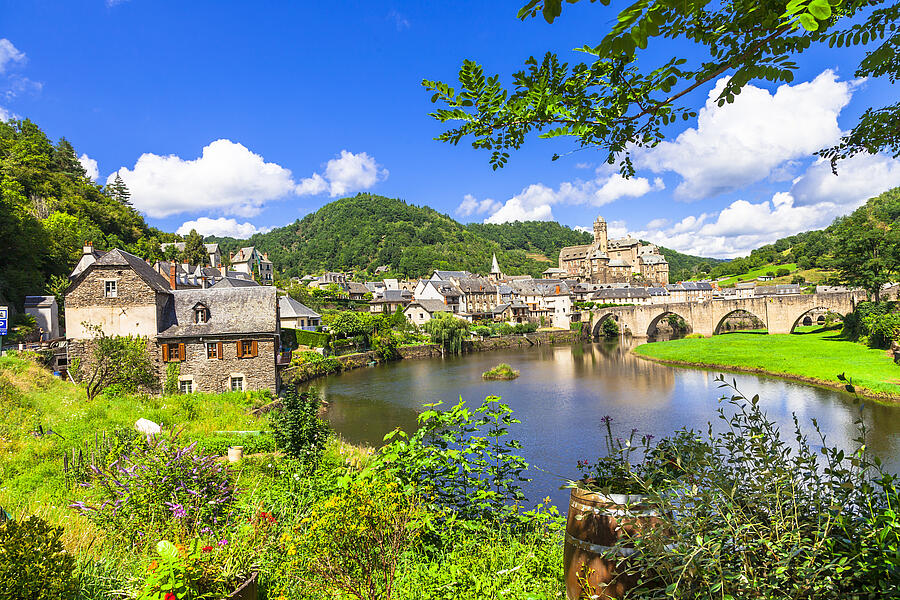 Vue pittoresque d’un village typique du Périgord avec son pont en pierre, sa rivière paisible et ses maisons traditionnelles, à proximité d’un camping Périgord en pleine nature.