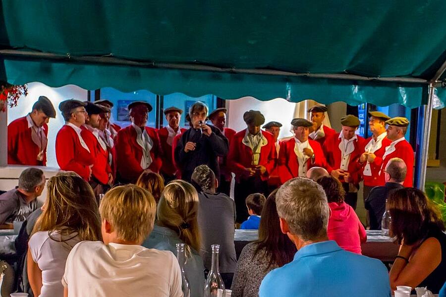 Une soirée conviviale avec un groupe folklorique local en tenue traditionnelle dans un camping des Pyrénées Atlantiques, offrant une immersion dans la culture basque.