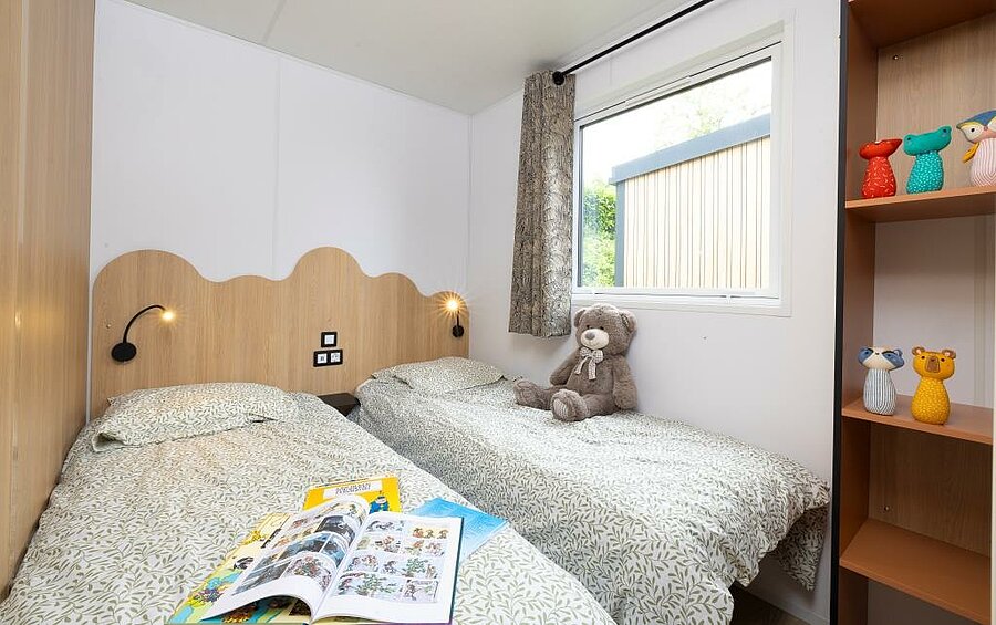 Location mobil-home Bretagne en camping, chambre enfants avec lits séparés, rangements et literie confortable pour un séjour familial serein.