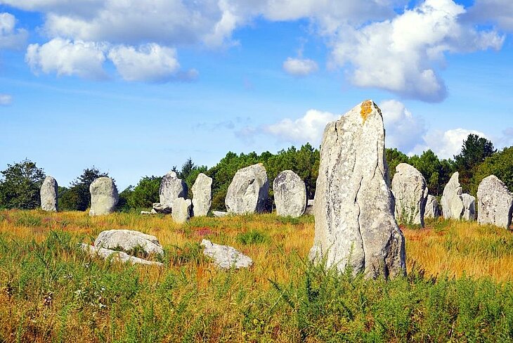 Alignements de Carnac, site mégalithique emblématique en Bretagne Alignements de menhirs de Carnac en Bretagne, pierres dressées au cœur de la lande, site préhistorique majeur à découvrir quand on se demande que faire en Bretagne.