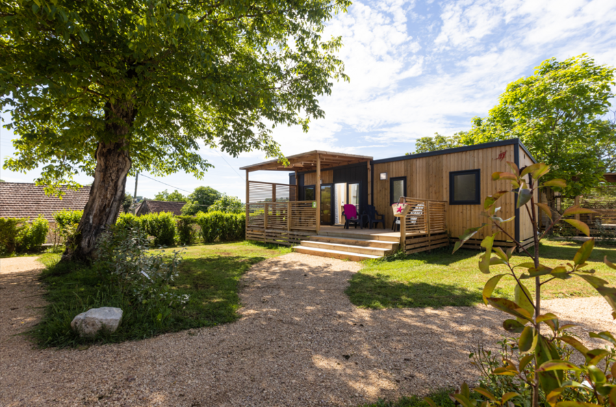 Mobil-home moderne en bois avec terrasse et jardin verdoyant