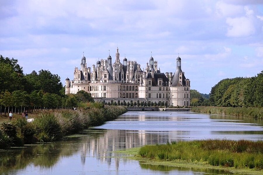 Vue du majestueux château de Chambord, entouré de verdure, emblématique des Châteaux de la Loire.