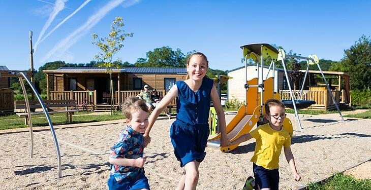 Enfants jouant dans une aire de jeux au camping