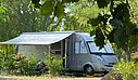 Emplacement pour camping-car ombragé, au cœur de la nature, avec un cadre paisible et verdoyant pour des vacances en plein air.