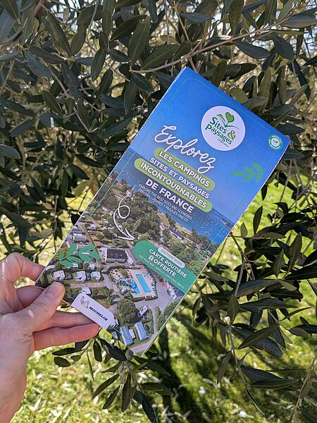 Main tenant la carte routière Michelin 2026 des campings Sites et Paysages, offerte gratuitement pour préparer un road trip nature en France.