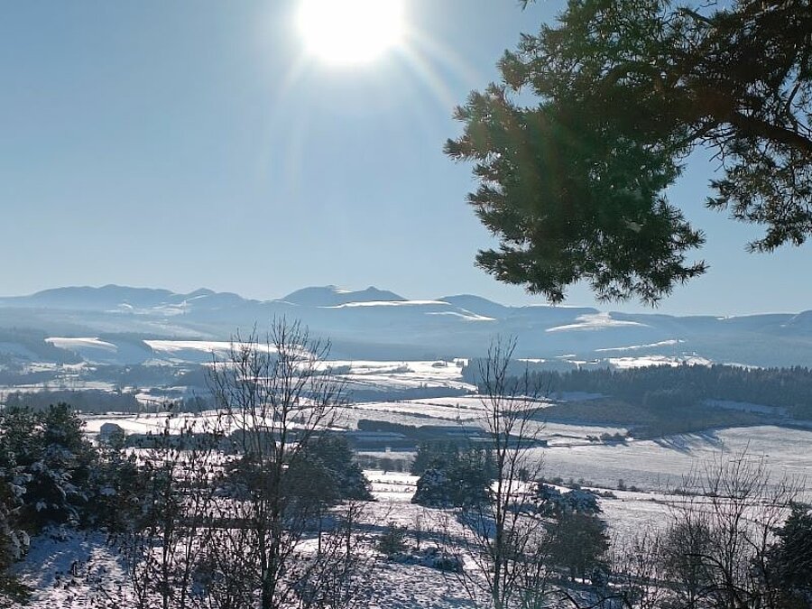 Paysage hivernal enneigé avec vue panoramique sur les montagnes sous un soleil éclatant. Un cadre naturel préservé idéal pour un séjour en camping caravaneige avec Sites et Paysages.