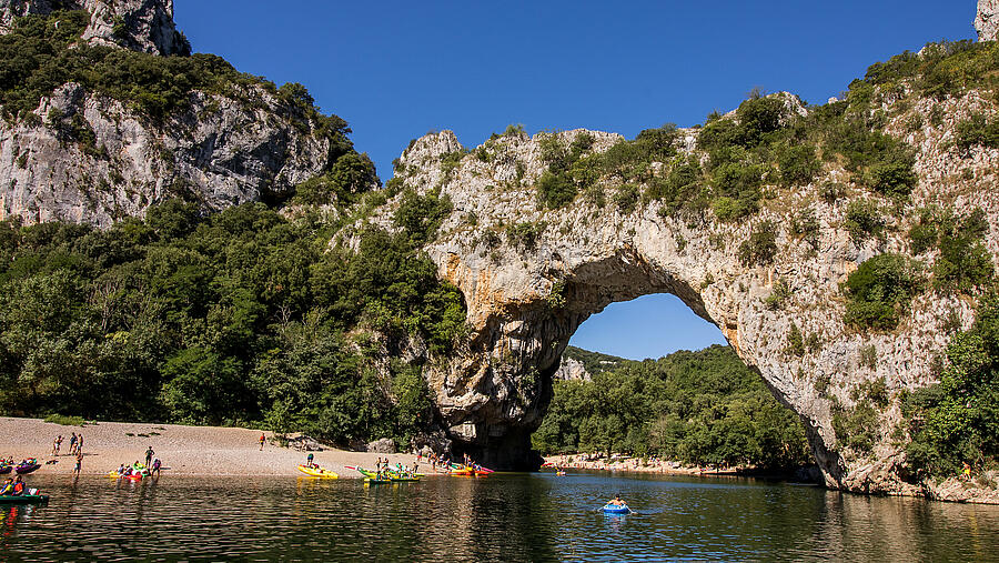Canoës au pied du Pont d’Arc à Vallon Pont d’Arc, site emblématique des gorges de l’Ardèche près des campings nature.