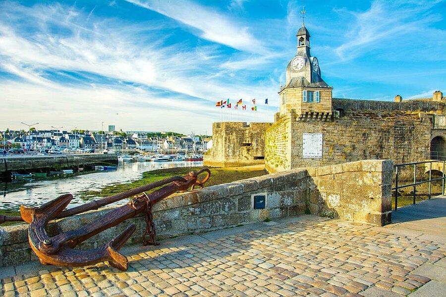 Ancre marine au premier plan face aux remparts et au beffroi de la Ville Close, port de Concarneau, idéal pour un séjour en camping Concarneau.