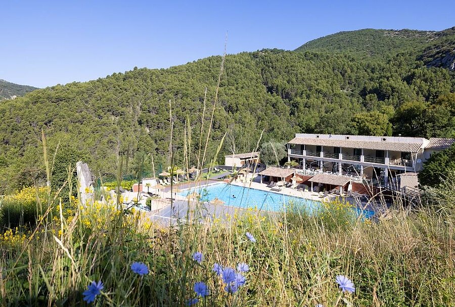 Piscine du camping L’Orée de Provence entourée de collines boisées, cadre idéal pour des vacances près de Valence
