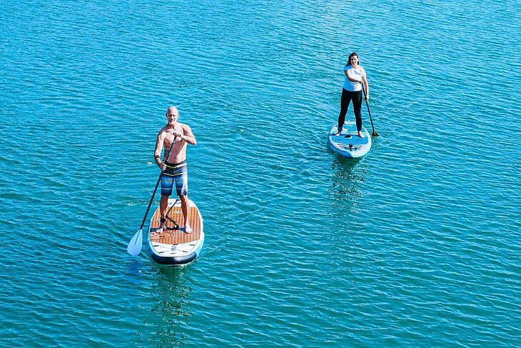 Un homme et une femme en paddle sur la mer à Telgruc-sur-Mer, activité idéale en plein air.