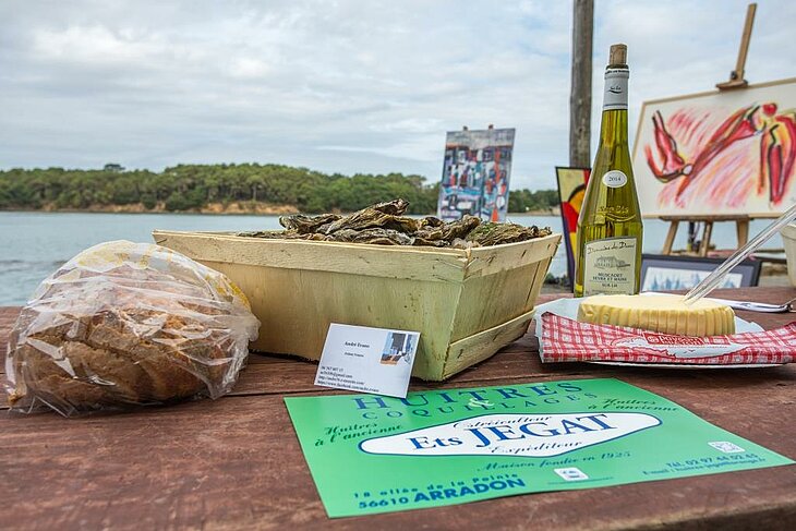 Dégustation de produits du terroir à Arradon, avec huîtres fraîches, fromage, pain traditionnel et muscadet, une pause gourmande recommandée par Philippe, propriétaire du camping.