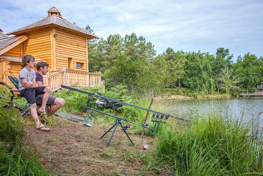 Père et fils pêchant au bord du lac
