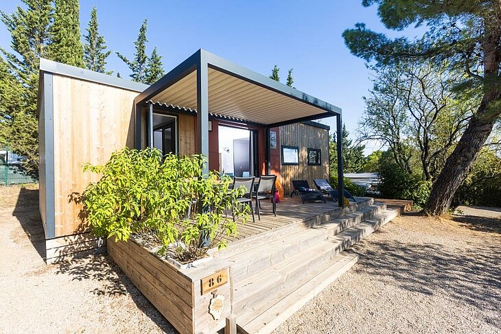 Mobil-home tout confort avec terrasse en bois au camping Sites et Paysages La Pinède, parfait pour un séjour tourisme à Lézignan-Corbières alliant nature et bien-être.