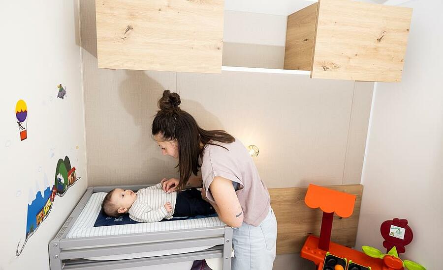 Maman changeant son bébé dans un hébergement de camping
