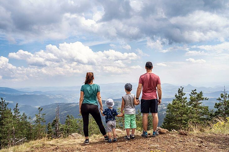 Famille admirant un panorama de montagne pendant une randonnée, moment nature et ressourçant.