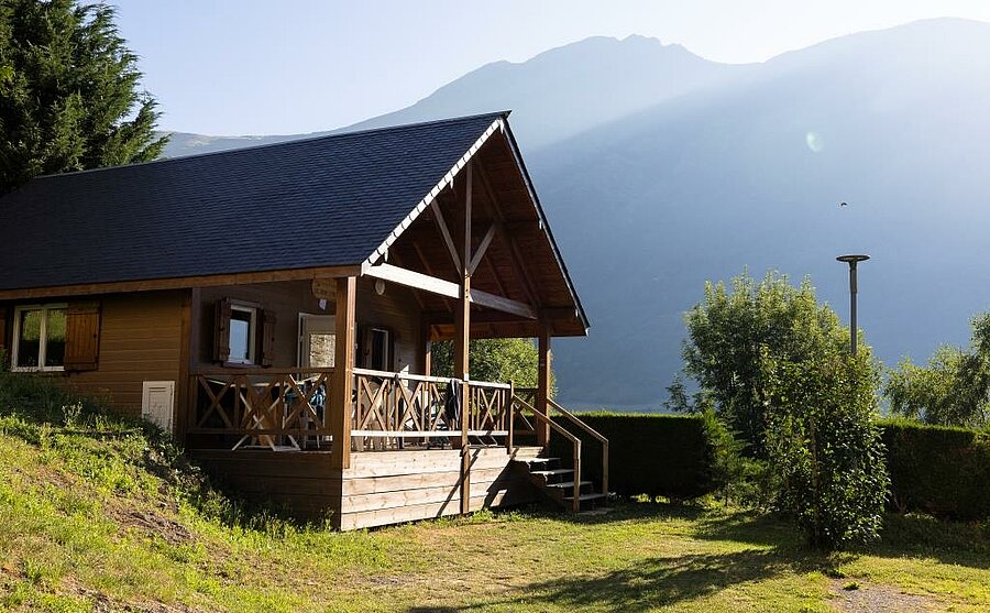 Chalet en bois avec terrasse dans un camping face aux montagnes des Hautes-Pyrénées, pour un séjour nature et détente.
