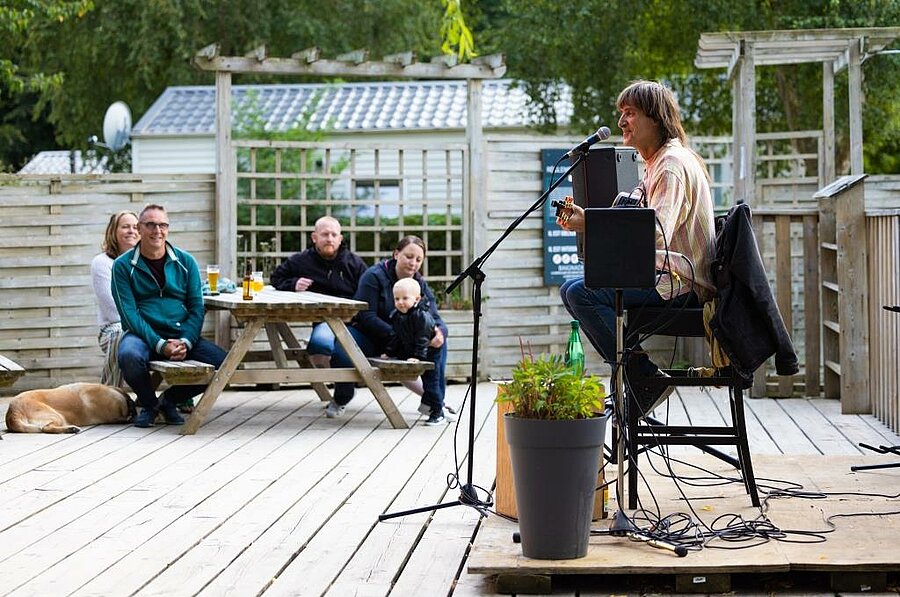 Scène de concert en plein air au camping près de Paimpol, familles réunies autour d’une animation musicale dans une atmosphère détendue.