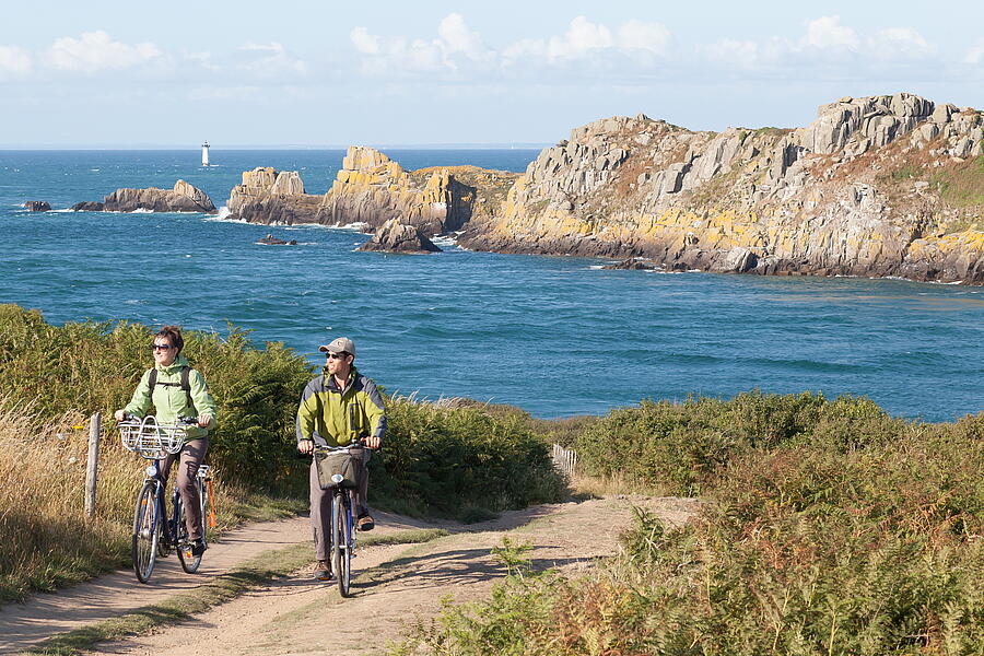 Couple à vélo profitant du paysage naturel près du camping à Cancale, Bretagne, avec vue sur la Pointe du Grouin.