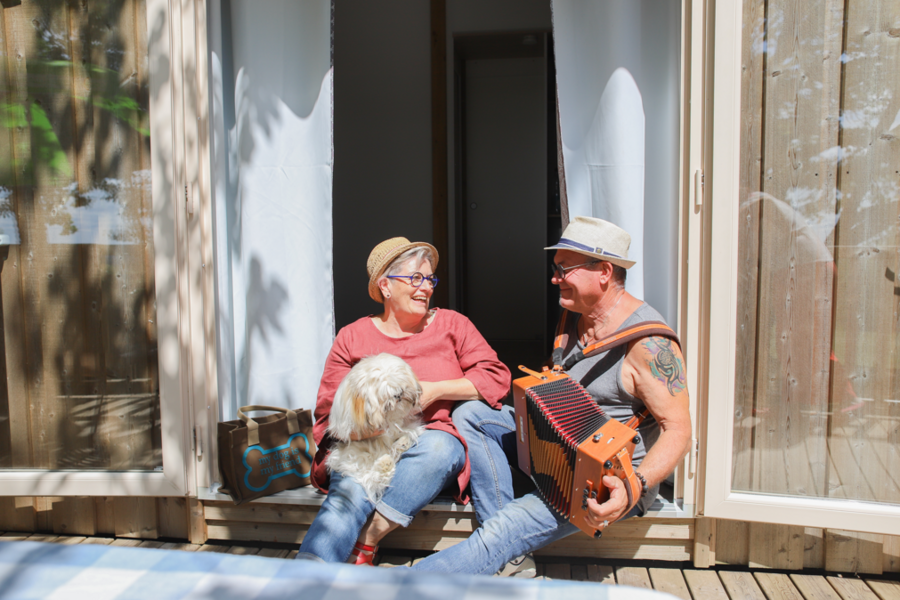 Vacances avec chien : couple devant un locatif accueillant les animaux