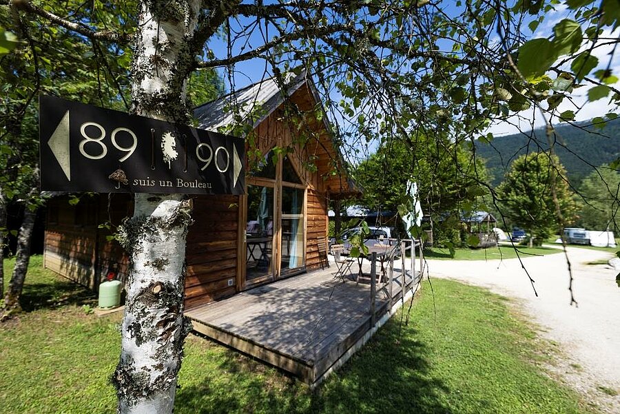 Chalet en bois niché dans un cadre verdoyant au camping, alliant luxe, nature et authenticité pour un séjour d’exception.