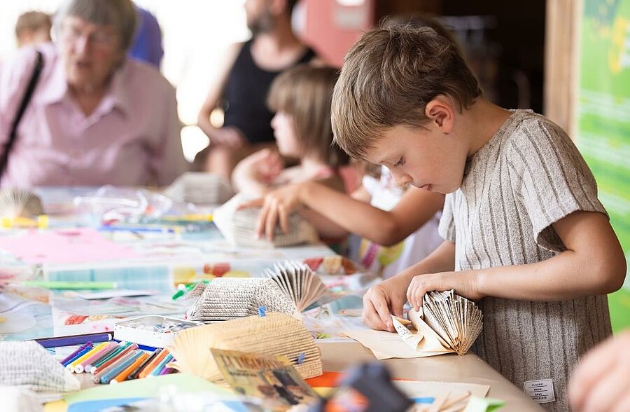 Enfants concentrés lors d’un atelier créatif en mini-club, animation encadrée en camping pour s’amuser et créer.