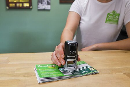 Départ au camping avec validation de la carte fidélité Camping Tour, illustrant son fonctionnement simple et rapide.