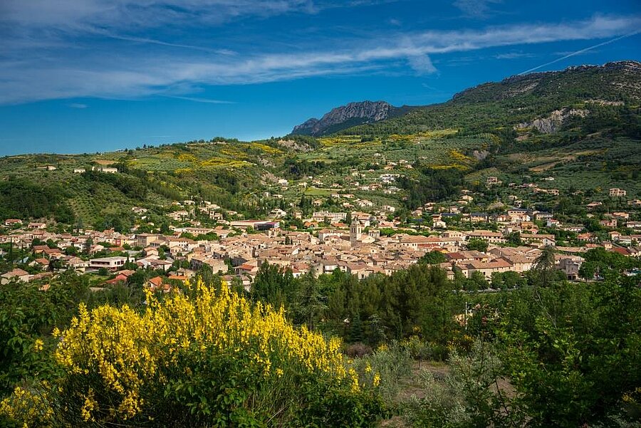 Vue panoramique d’un village de la Drôme entouré de collines verdoyantes, idéal pour un séjour camping nature