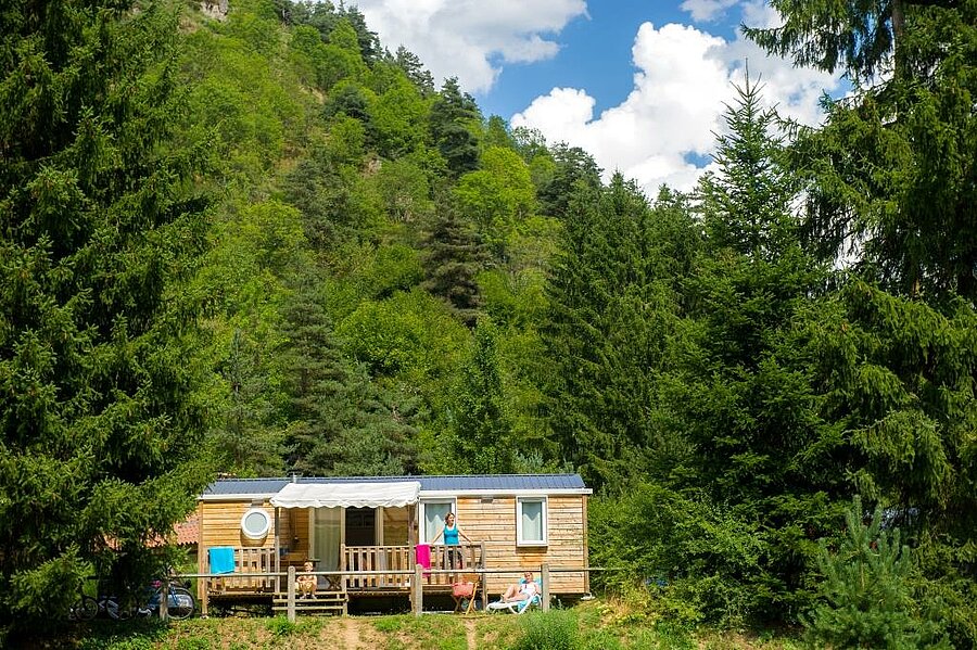 Mobil-home en bois niché au cœur de la nature dans un camping Sites et Paysages, idéal pour un séjour reposant lors du week-end de l’Ascension.
