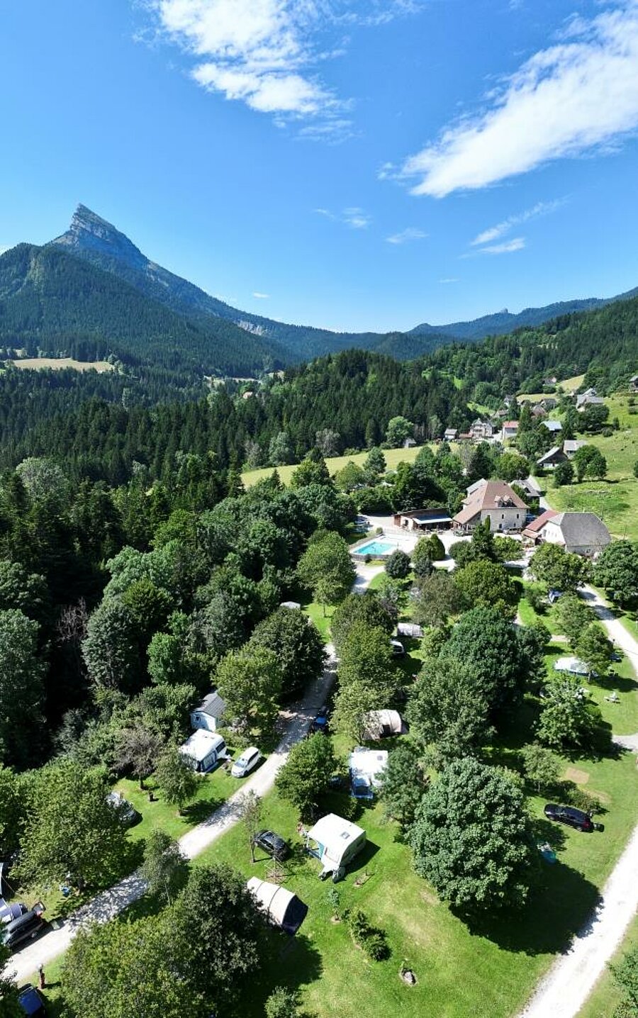 Vue aérienne d’un camping Sites et Paysages niché au cœur des montagnes, parfait pour un séjour nature lors du pont de mai.