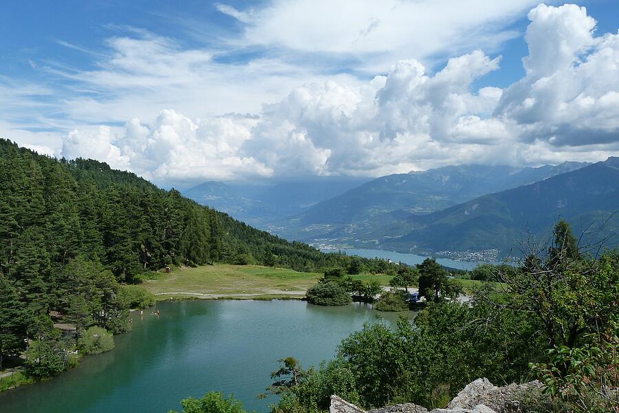 Vue panoramique sur un camping près du lac de Serre-Ponçon, entouré de montagnes et de forêts verdoyantes, idéal pour des vacances nature en famille.