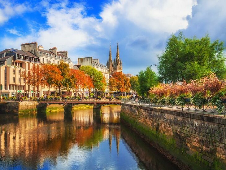 Escapade à Quimper en Bretagne aux couleurs d’automne Ville bretonne traversée par un cours d’eau, entourée d’arbres aux couleurs d’automne.