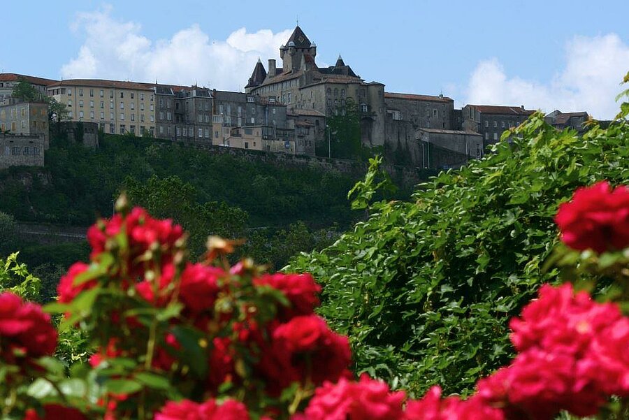 Vue du château d’Aubenas entouré de verdure et de fleurs, une destination incontournable pour un séjour en camping dans la région.