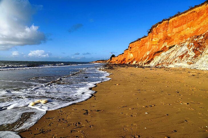 Falaises ocres et plage de Pénestin, un site naturel à explorer lors d’une visite de Rochefort-en-Terre et de ses environs côté mer.