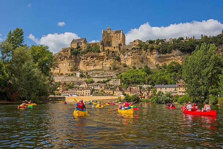 Descente en canoë sur la Dordogne avec vue sur le village de La Roque-Gageac, une activité nature incontournable à faire près de Loupiac.