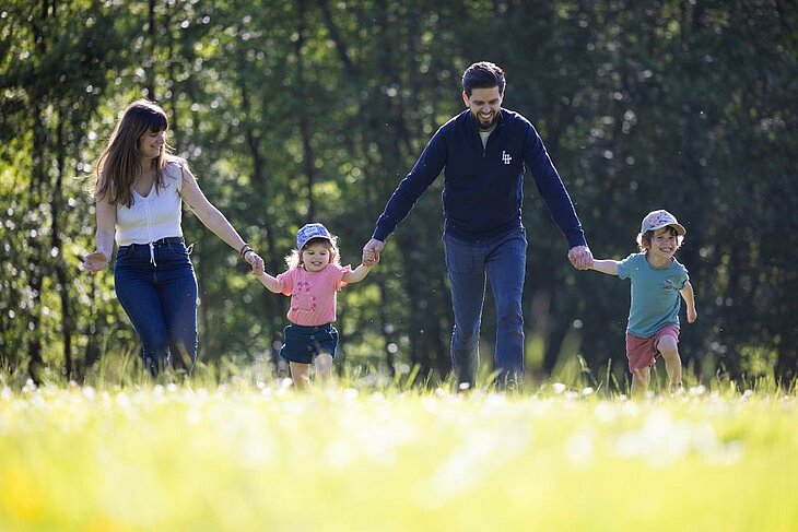Réservez vos vacances en famille dans un camping nature Famille avec enfants se promenant dans un camping nature, idéale pour réserver des vacances familiales conviviales.