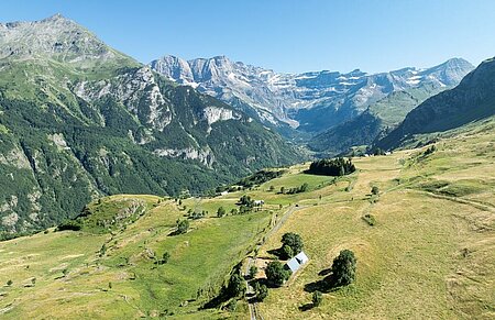 Panorama alpin avec prairies et chalets, parfait pour des vacances camping dans un département préservé
