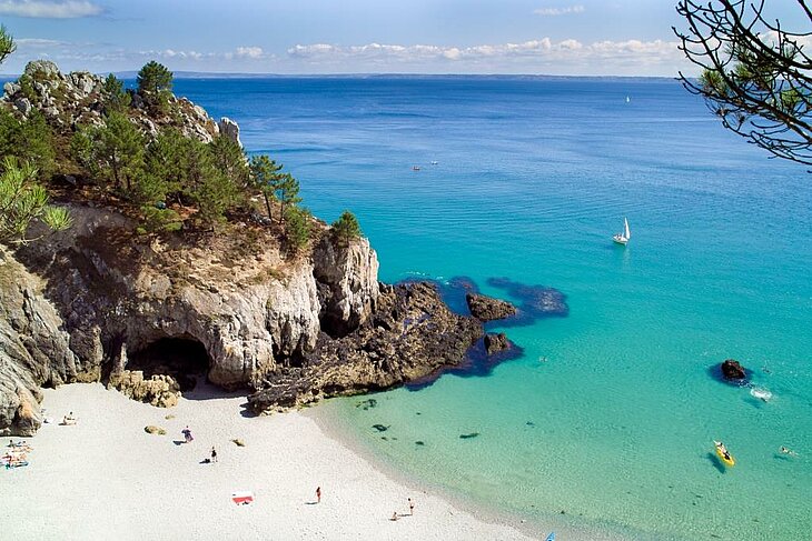 Eau turquoise, sable blanc et grotte creusée dans la falaise à Morgat, près de Telgruc-sur-Mer.