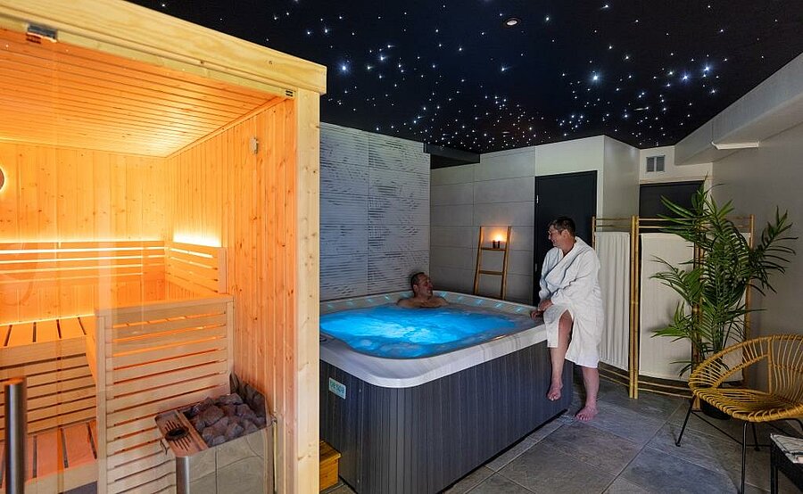 Espace bien-être chauffé en camping hiver avec sauna en bois et spa intérieur, idéal pour se détendre après une journée au grand air.