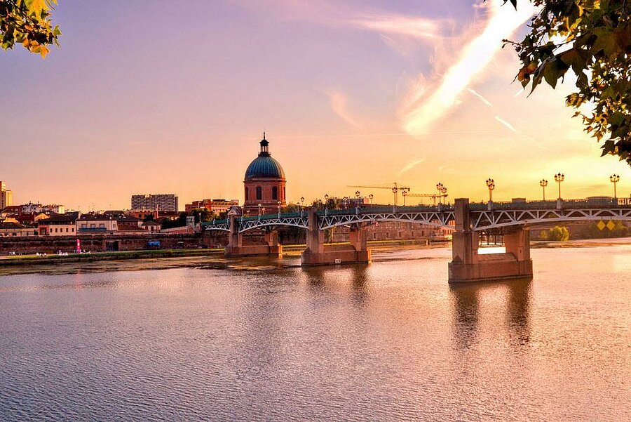 Vue sur le Pont Saint-Pierre et le Dôme de La Grave à Toulouse au coucher du soleil, depuis les berges proches du camping.