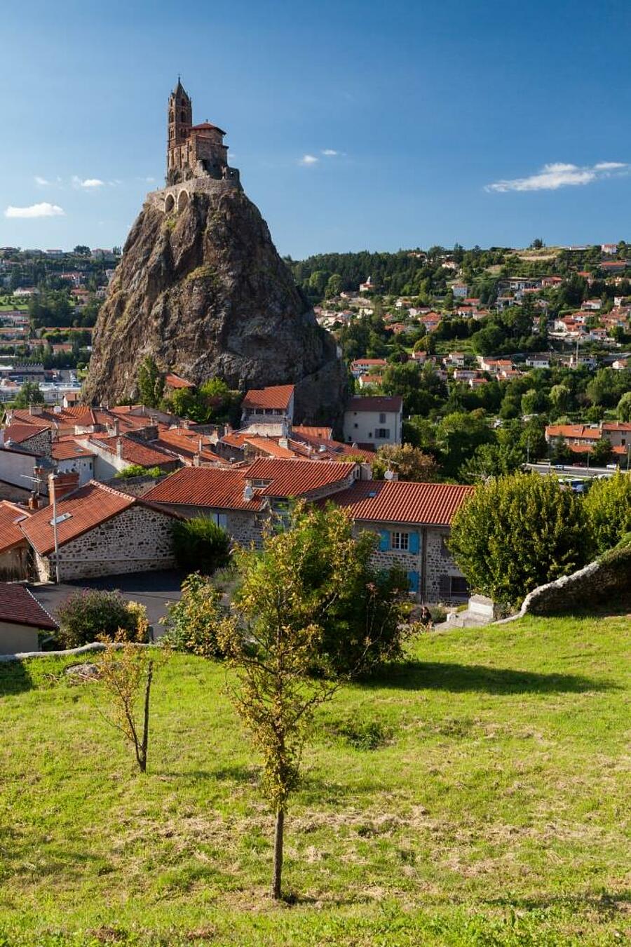 Vue emblématique de la chapelle Saint-Michel d’Aiguilhe perchée sur son rocher volcanique au Puy-en-Velay, un site incontournable à découvrir lors de vacances en camping en Haute-Loire.