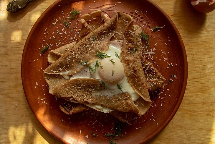 Galette bretonne au sarrasin garnie d’un œuf fermier, spécialité incontournable à savourer lors d’un séjour gastronomique autour de Plomeur.
