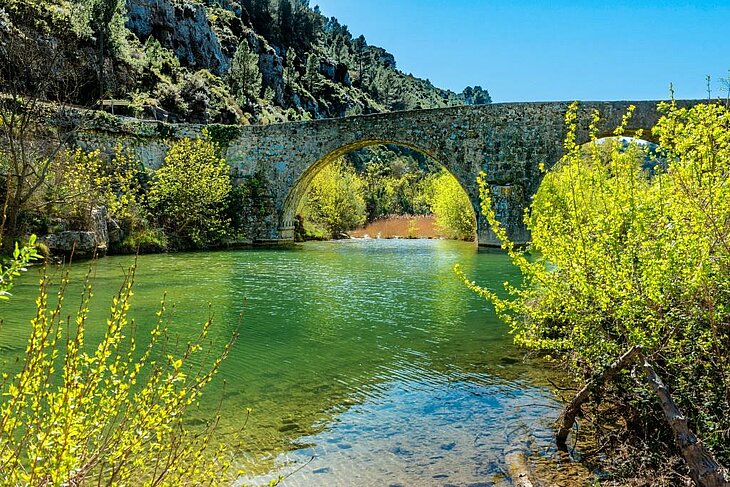 Pont de pierre traversant les eaux turquoise des gorges de l’Orbieu, un lieu idéal pour les activités de pleine nature lors d’un séjour tourisme à Lézignan-Corbières.