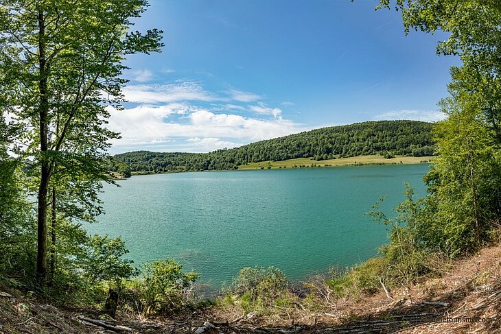 Panorama du lac d’Ilay, entouré de forêts et de collines verdoyantes, une balade incontournable à faire autour de Mesnois.