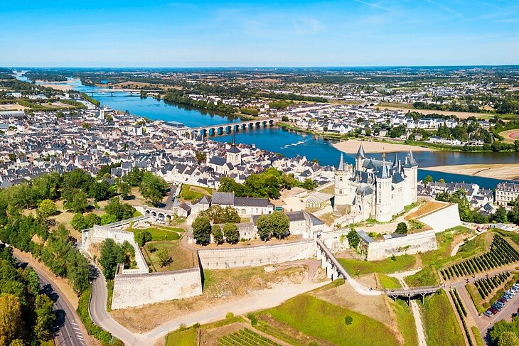 Saumur et son château dominant la Loire Vue aérienne du château de Saumur, de la vieille ville et des ponts traversant la Loire, au cœur de l'Anjou.