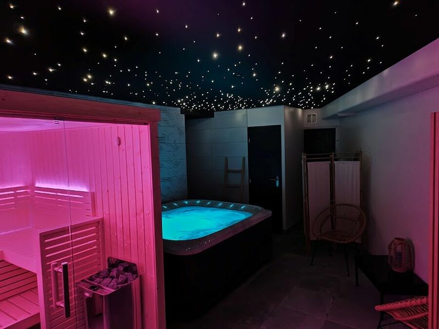 Espace bien-être avec spa, sauna et éclairage étoilé, idéal pour se détendre après une journée en camping caravaneige. Une expérience relaxante au cœur de l’hiver.