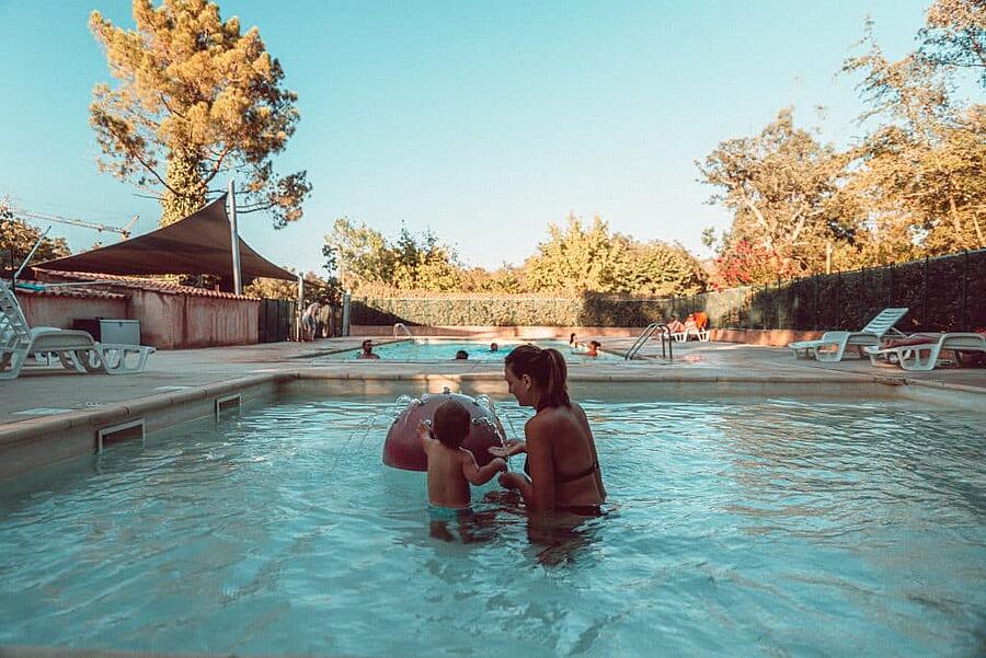 Mère et enfant dans la pataugeoire d'un camping près de Porto-Vecchio, offrant un espace de détente idéal pour des vacances en famille en Corse du Sud