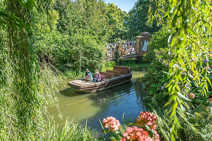 L'Odyssée botanique © Terra Botanica Des visiteurs naviguent à bord d'une gabarre sur un canal bordé de plantes et d'arbres dans les jardins de Terra Botanica.