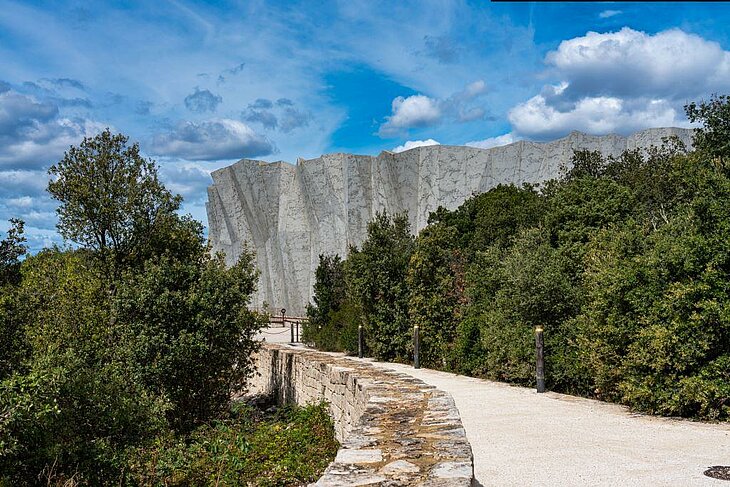 Entrée monumentale de la Grotte Chauvet 2 entourée de forêt, site culturel majeur à visiter autour de Joannas.