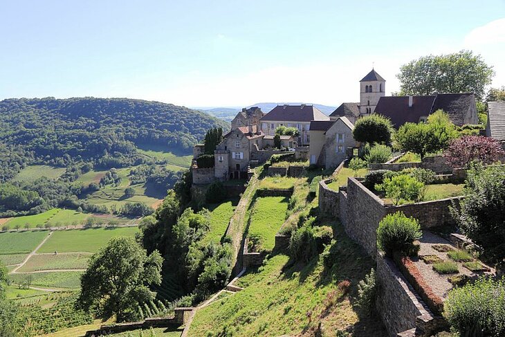 Vue sur le village perché de Château-Chalon et ses vignobles en terrasses, un lieu emblématique à visiter autour de Mesnois.